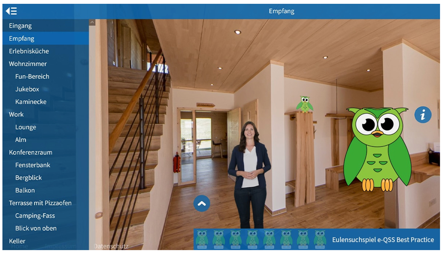 Innenansicht eines Empfangsbereichs mit Holztreppe. In der Mitte steht eine Person. Auf dem Bildschirm sind gezeichnete grüne Eulen und ein Navigationsmenü zu sehen.